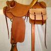 #2609; 58 Wade Tree, 15 1/2" seat, wood post horn 2 3/4" high, 3 1/2" cap rawhide bound; cantle 4 1/2" high Cheyenne roll rawhide bound; 7/8 flat plate rigging, 4" brass stirrups, all rough out , flower carved rear jockeys, rawhide on gullet, bucking rolls, scabbard rings, saddle bags.