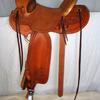 #2107; Glenn's Wade Tree, 15 1/2" seat, horn 2 1/2" high, 3 1/4" cap rawhide bound, cantle 5" rawhide bound Cheyenne roll, 7/8 flat plate rigging, tin bound overshoe stirrups, rough-out seat with border stamp, border stamped skirts, fenders, rear jockeys, floral carving in corners, bucking rolls.