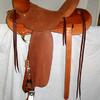 #2207; 58 Wade Tree, 16" seat, wood post horn 2 1/2" high, 3 1/4" cap mule hide wrapped, rawhide bound; 4 1/2" cantle Cheyenne roll, rough-out seat & fenders, gullet skirts & rear jockeys smooth, 7/8 flat plate rigging, saddle bags, 4" wood tin-bound bell stirrups.