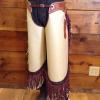 Cream colored chink with flower carved overlays.  Burgundy twisted double fringe.  1 concho on each leg overlay.