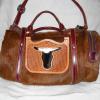 brown hair-on bag with cut-out steer head with black & white hair-on hide behind it